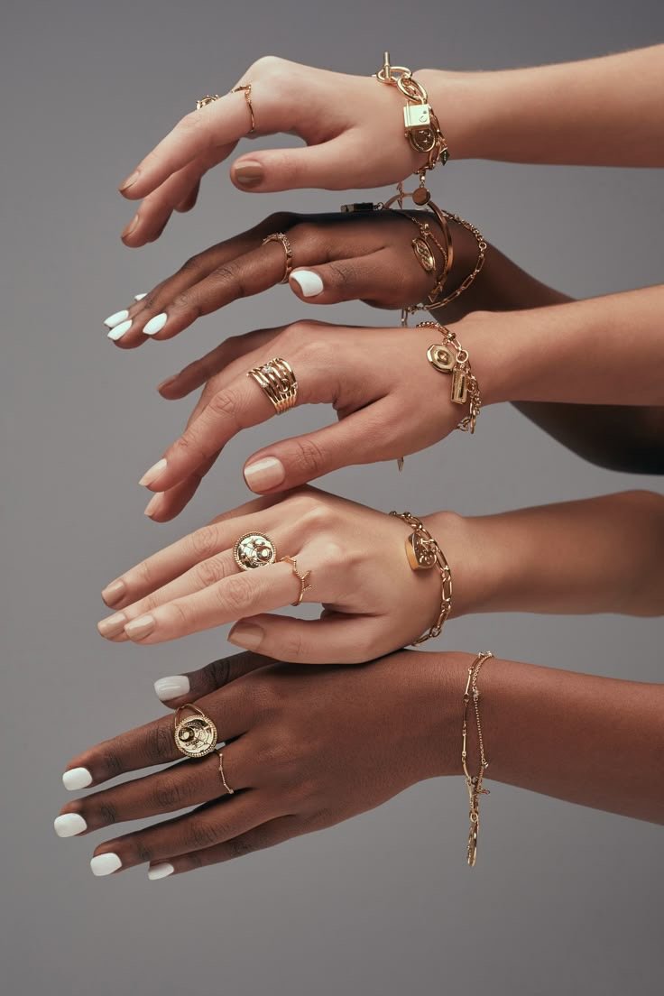 Stacked gold rings and bracelets on layered hands