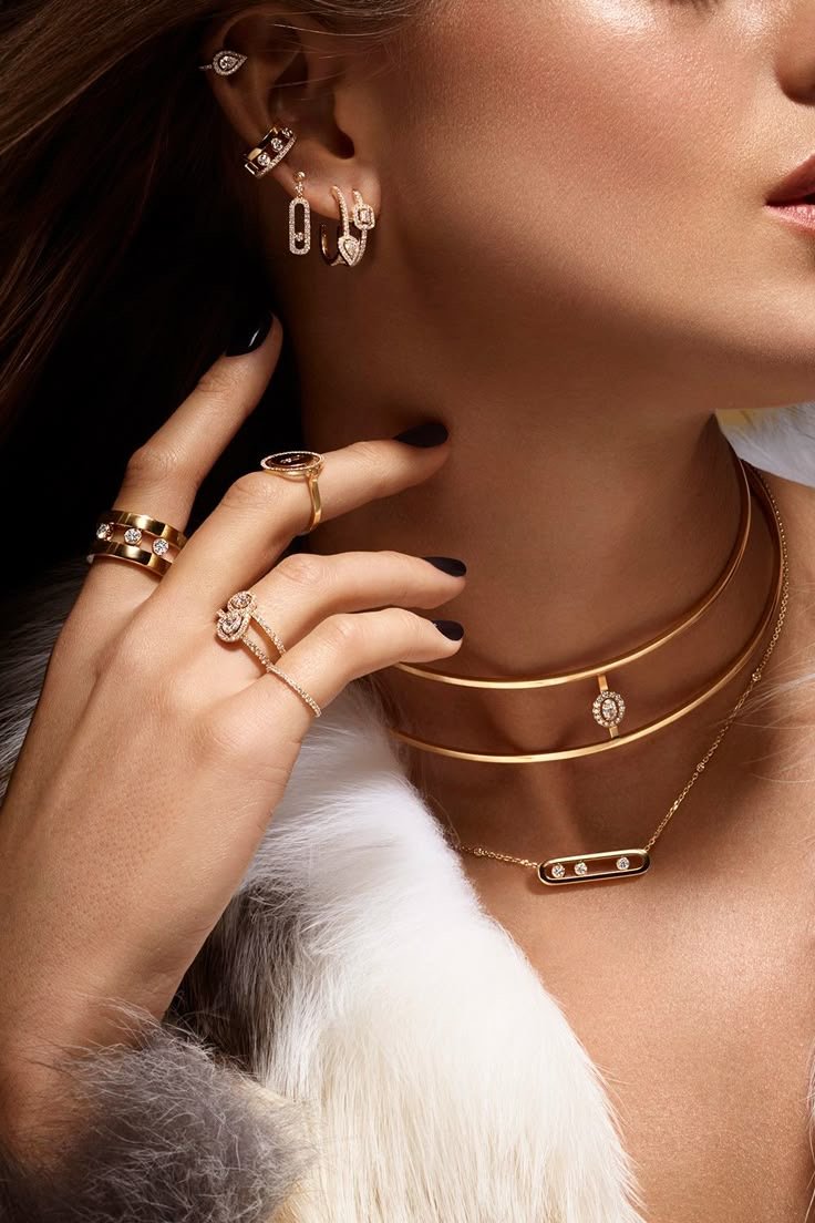 Layered gold necklaces, earrings and rings on the neck and ear